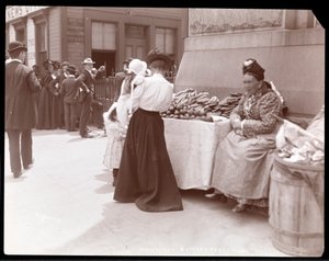 En fruktförsäljare vid Battery Park, som förmodligen väntar på immigranter från Ellis Island, New York, ca 1901 (silvergelatinprint)